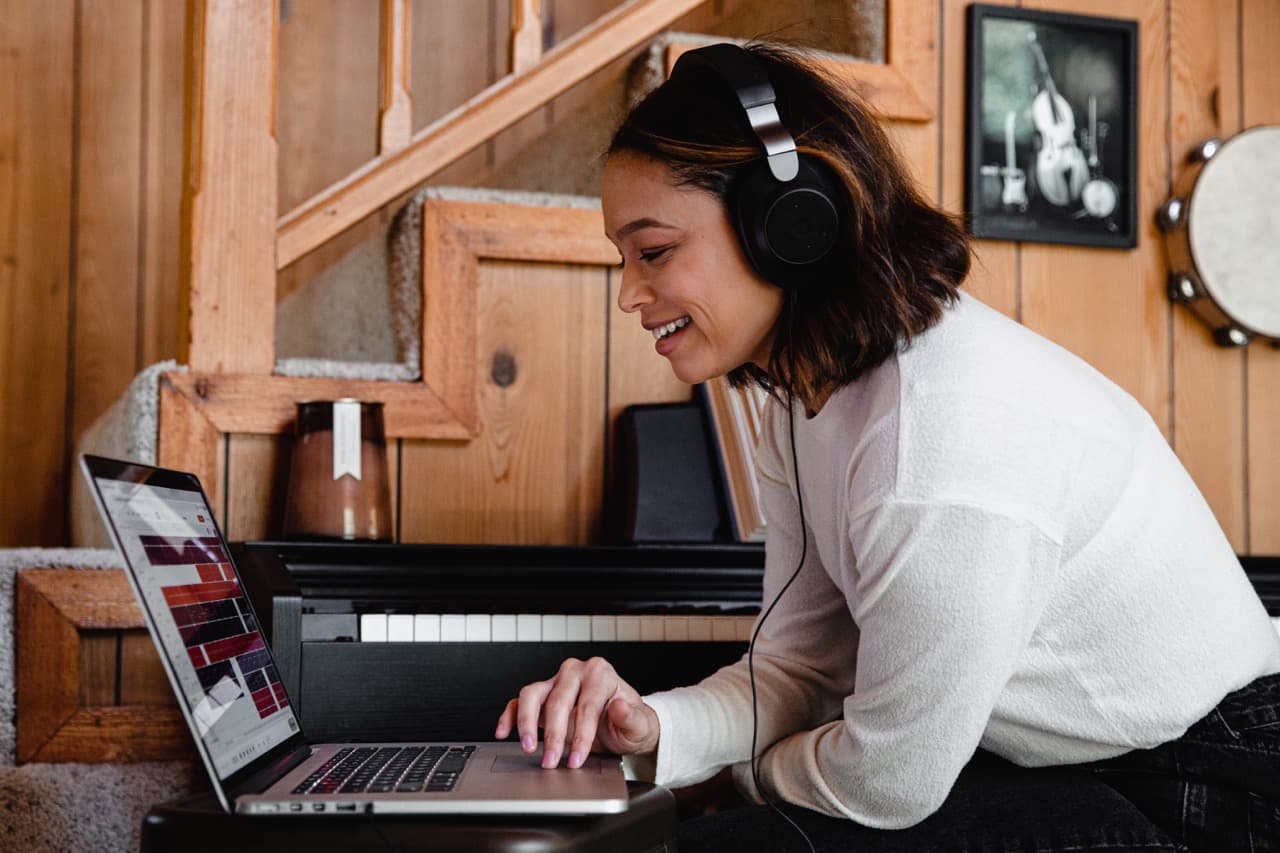 Woman using computer with headphones on